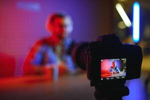 Young man recording or streaming podcast using microphone at his small broadcast studio. Content creator. photo
