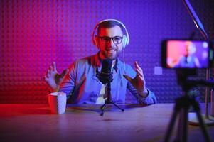 A blogger records content in his studio. The host of the blog is a young man who is very enthusiastic about telling his subscribers a story. photo