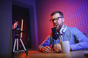 A blogger records content in his studio. The host of the blog is a young man who is very enthusiastic about telling his subscribers a story. photo