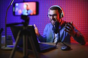 A blogger records content in his studio. The host of the blog is a young man who is very enthusiastic about telling his subscribers a story. photo