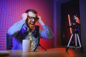 vlogger using smartphone to film podcast in studio. blogger with mobile phone, microphone and headphones filming for social media broadcasting career. photo