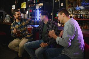Friends resting in the pub with beer in hands. Having conversation. photo