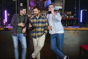 Friends resting in the pub with beer in hands. Having conversation. photo