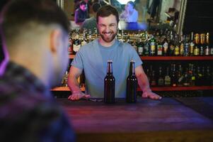 Portrait Of Smiling Male Bar Owner Standing Behind Counter photo