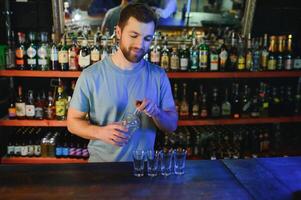 Handsome bar tender standing behind his counter in a pub photo