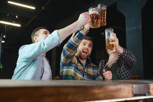 Soccer fans at the bar. Happy football fans cheering at bar and drinking beer while bartender serving beer at the background photo