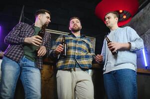 Friends resting in the pub with beer in hands. Having conversation. photo