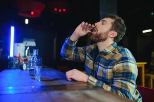 Sad man sitting at bar counter, alcohol addiction photo