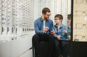 Father with cute son. Family buy glasses photo