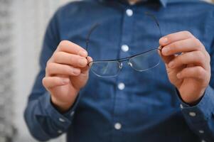 Man evaluating quality of glasses in optical shop photo