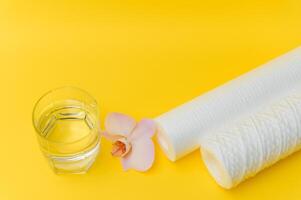 cartridges for water purification on a yellow background. Concept of clean water at home photo