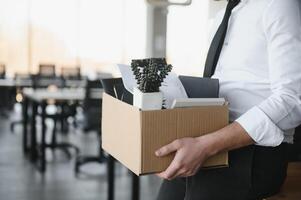 Close-up Of A Businessperson Carrying Cardboard Box During Office Meeting photo
