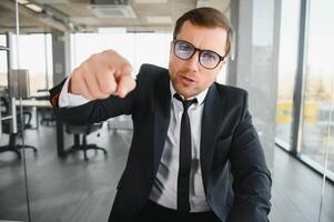 Angry senior businessman sitting at his desk and screaming photo
