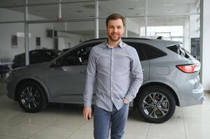 a man chooses a new car for himself walks between the rows in a car dealership photo