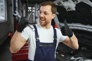Portrait of a smiling fixing a car engine in his garage photo