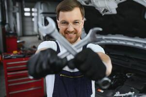 Portrait of a smiling fixing a car engine in his garage photo