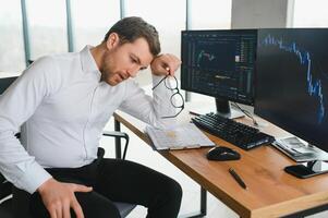 Serious business man trader analyst looking at computer monitor, investor broker analyzing indexes, financial chart trading online investment data on cryptocurrency stock market graph on pc screen. photo