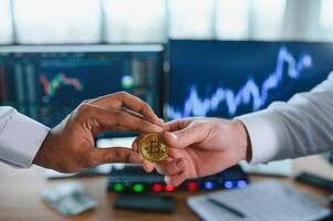 View of hand holding a bitcoin and giving it to other people. Cryptocurrency trading concept photo