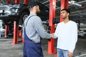 Mechanic, car servicing at garage - concept of timely customer service, car maintenance and deal agreemnet. photo