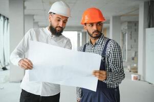 contento trabajadores a construcción sitio, joven civil ingeniero gerente y arquitectos indio y árabe ingenieros foto