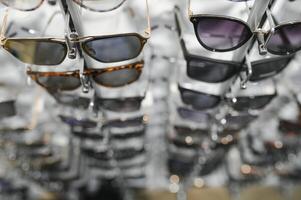 Sunglasses on display shelves in glasses store photo