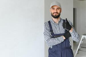 smiling repairman standing near stepladder and looking at camera photo