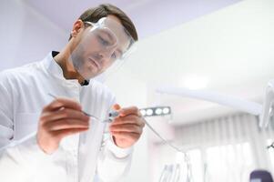 Bottom view. Dentist man with a tool in his hand. photo