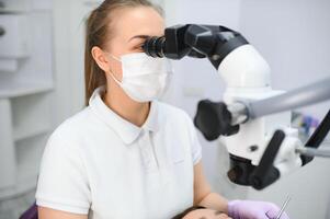 professional dentist examination patient with microscope at the office photo