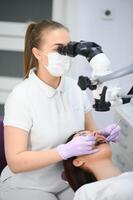 professional dentist examination patient with microscope at the office photo
