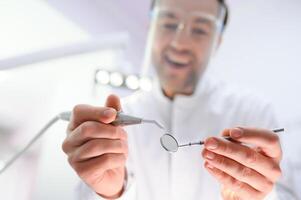 Bottom view. Dentist man with a tool in his hand. photo