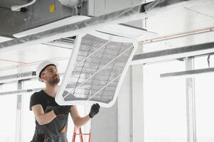 technician cleans air conditioner system in a modern apartment photo