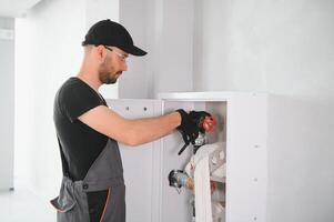The worker installs or inspects Fire extinguisher and fire hose reel in building corridor photo