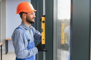 Worker installing plastic window indoors. photo
