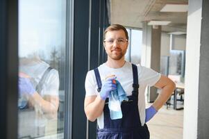 An employee of a professional cleaning service washes the glass of the windows of the building. Showcase cleaning for shops and businesses. photo