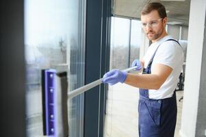 An employee of a professional cleaning service washes the glass of the windows of the building. Showcase cleaning for shops and businesses. photo