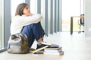 Lonely sad schoolgirl while all her classmates ignored her. Social exclusion problem. Bullying at school concept. photo