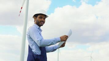 Indian wind turbine worker. Asian engineer maintains and controls wind turbine energy generation on the background of windmills. Concept of sustainable future video
