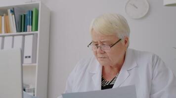 Doctor having short rest by looking aside then proceeds to work. video