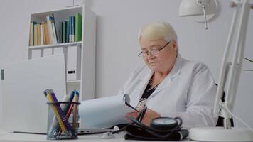 Double checking patients histories done by nurse using computer and paper prints. video