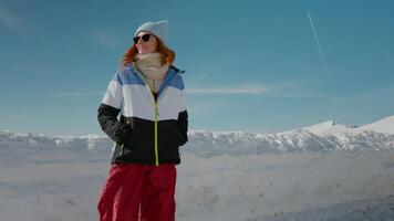 Winter equiped traveler spinning around herself smiling while walking in the mountains. video