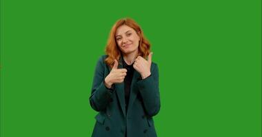 Caucasian woman shows double thumbs up to the camera and nods with a smile on green screen background. video