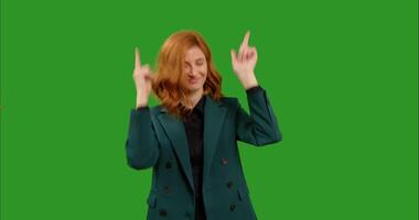 Female points at the camera and dances on green screen background . video