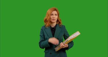 Tired business woman while standing In front of green screen background with big folder in her hands. video