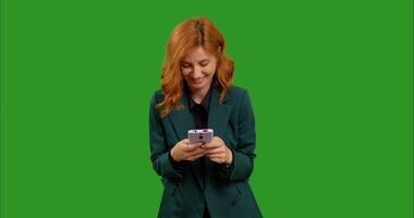 Female reading text message on her mobile phone over green screen background chroma Key. video