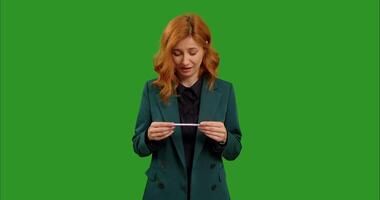 Woman takes pregnancy test and is happy with positive result on chroma key background. video