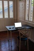 A notebook computer and a combination lock are placed on a black table. A hacker's notebook computer that prepares to compromise the target's system to steal sensitive information. photo