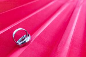 Two gold rings for couples prepared to be given to each other on Valentine's Day on a red background and two gold rings also symbolize promise between lovers to love and care for each other forever. photo
