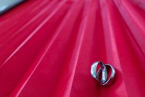 Two gold rings for couples prepared to be given to each other on Valentine's Day on a red background and two gold rings also symbolize promise between lovers to love and care for each other forever. photo