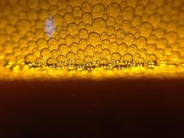 The backdrop and blurred background of the golden beer bubbles poured into the glass creates a large number of beer bubbles rising above the beer below. Copy Space for text design work photo