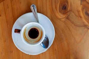 Blurred background,A set of hot white coffee cups that can be served to customers and customers to eat, placed on a wooden table and can see the coffee stains on the bottom of the cup and on the bowl. photo